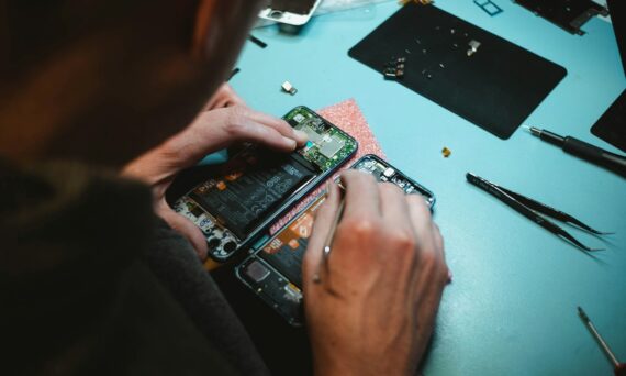 person repairing smartphones under a lighted table