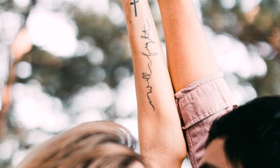 woman in black shirt with tattoo on her left arm