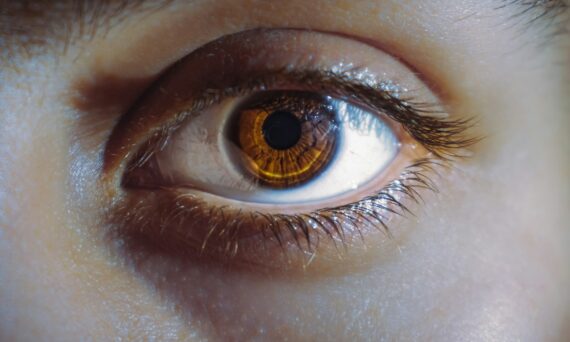 persons brown eyes in close up photography