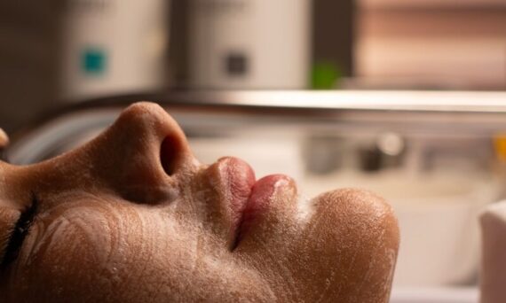 Woman's face with cleansing foam during facial treatment.
